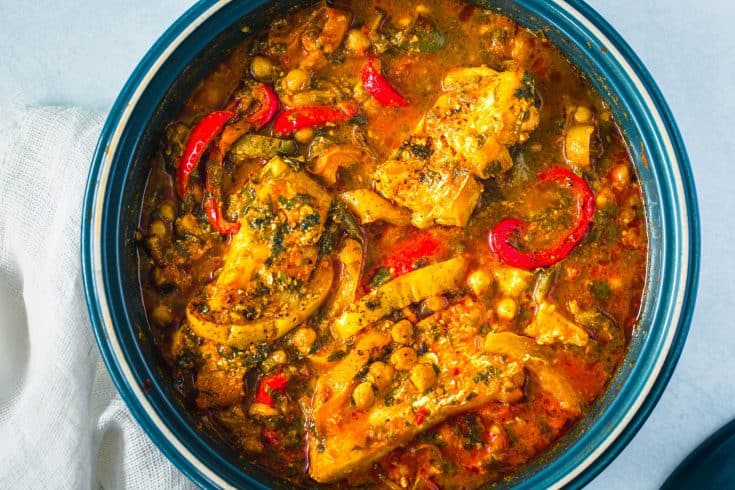 close up of fish braised in tomatoes and peppers