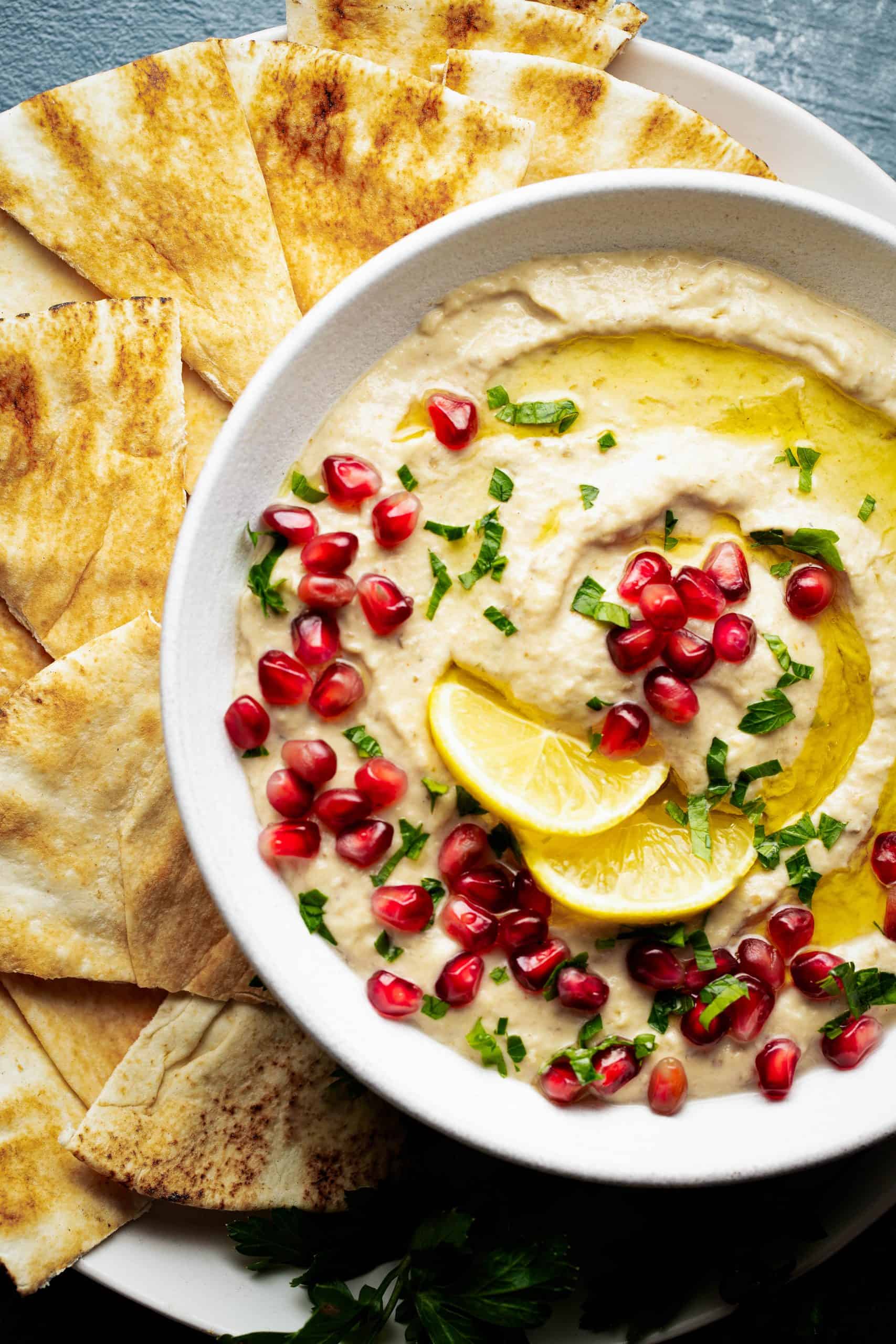Close up of baba Ganoush dip with olive oil, parsley and pomegrante seeds on top